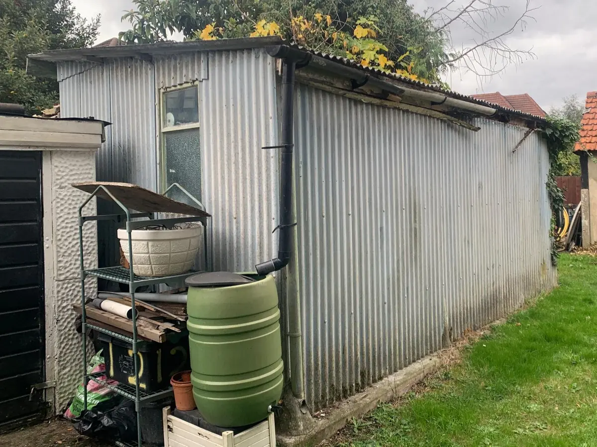 Asbestos garage roof removal London — garage with corrugated asbestos cement roof before removal