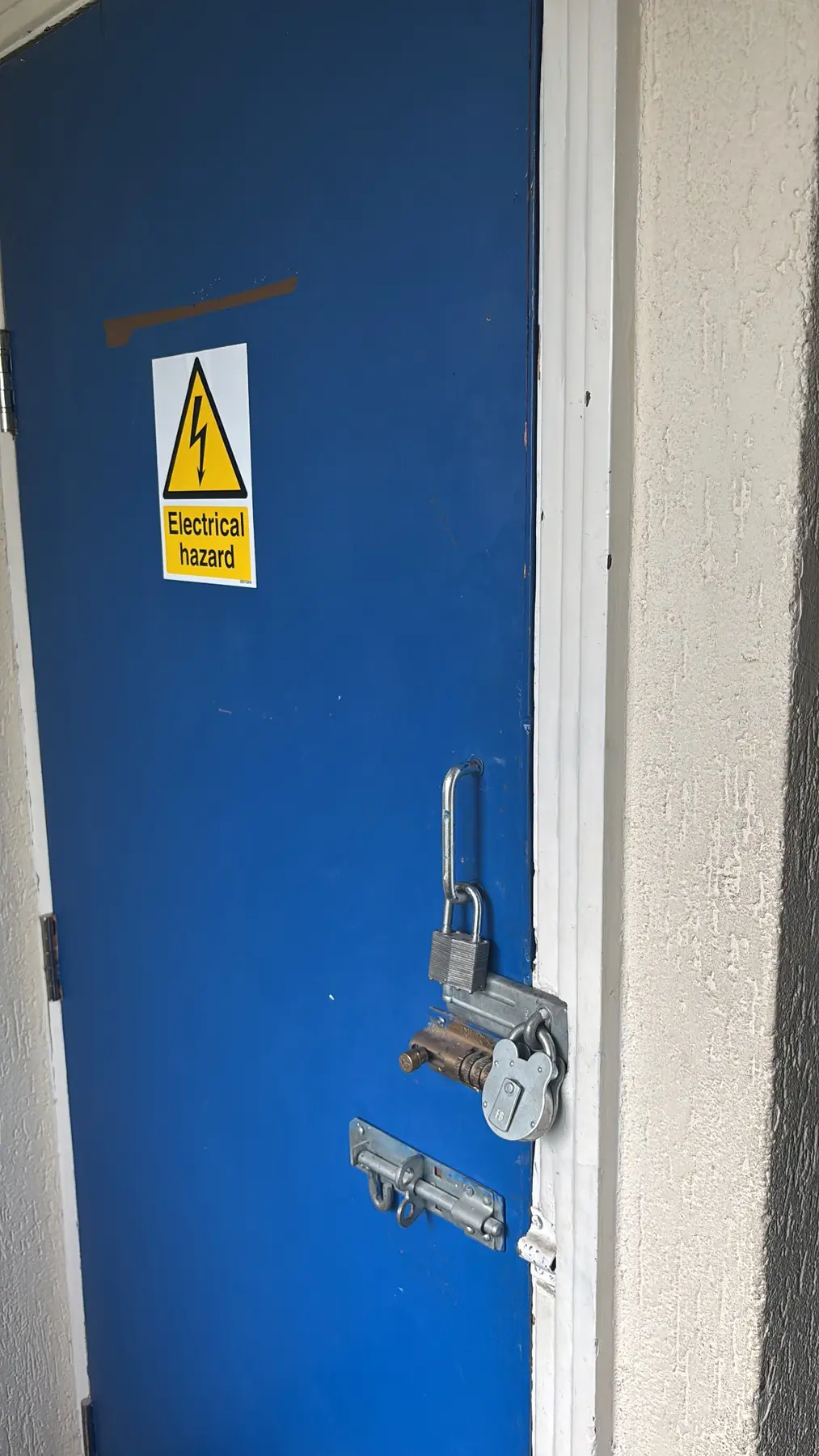 Electrical cupboard and surrounding panel area assessed before asbestos removal in London