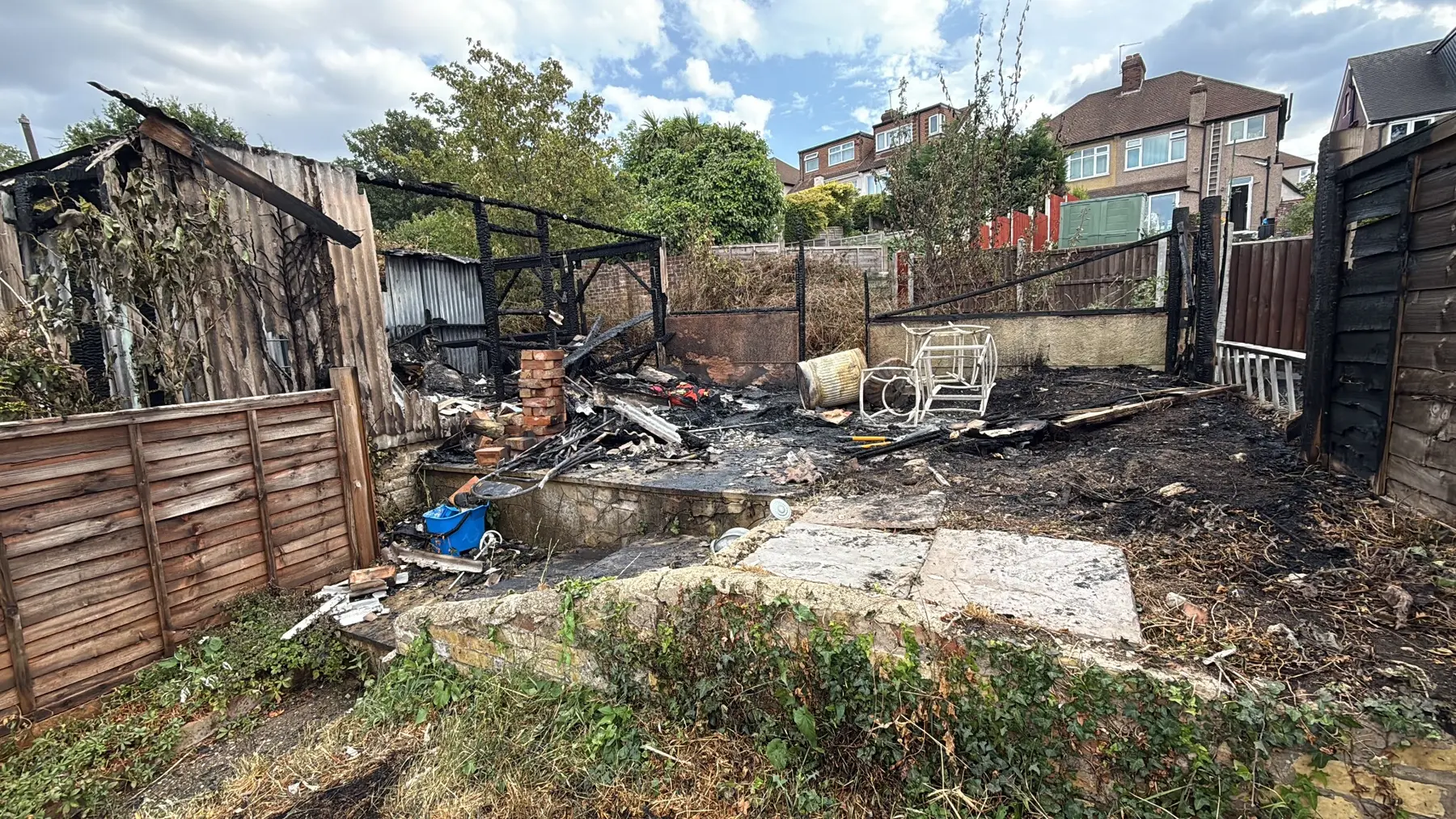 Fire-damaged garage site requiring asbestos assessment and controlled clearance in London